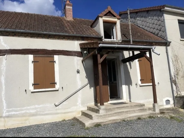 Façade de longère avant travaux : enduit gris, fissures rebouchées en blanc